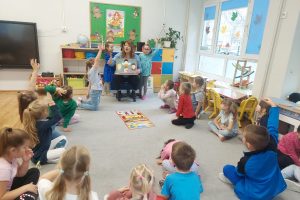 dzieci siedzą w kręgu i pani pokazuje ilustracje dotyczące praw dziecka